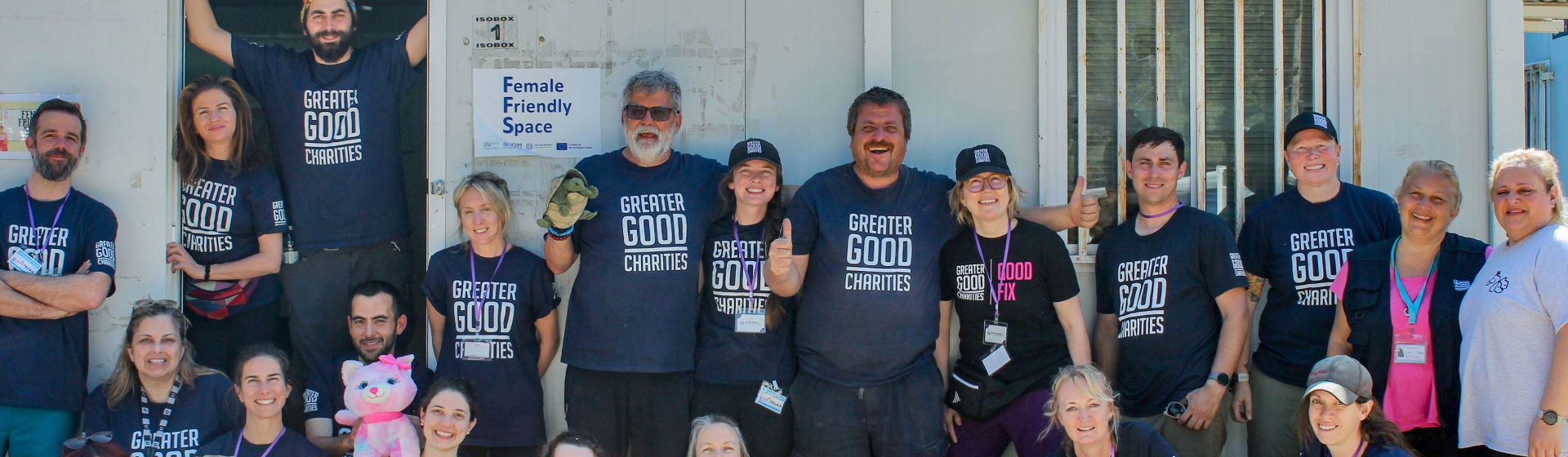 group of volunteers and Greater Good Charities employees posing together at a refugee shelter in Greece